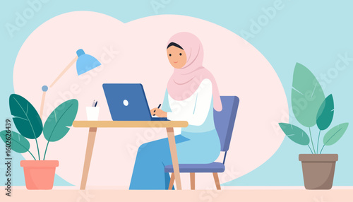 A smiling Muslim woman in a pink hijab working on a laptop at a modern wooden desk.