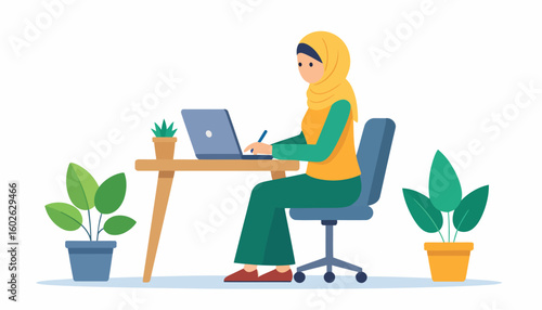 Focused Muslim woman in a yellow hijab and green outfit working on a laptop at a wooden desk.