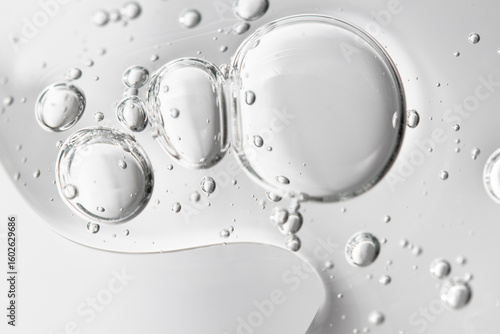 Hyaluronic acid, lotion and tonic bubbles flow down the transparent surface, macro.