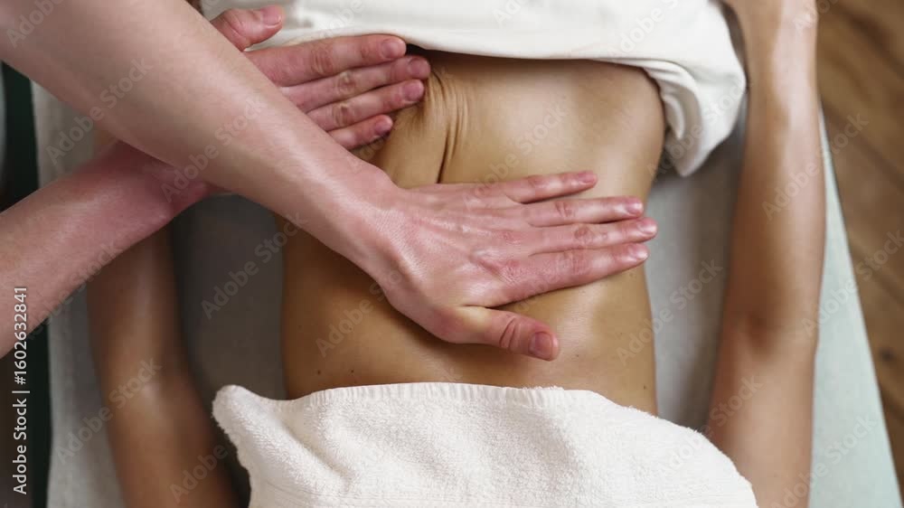 Professional masseur applying pressure with hands on client abdomen during relaxing massage session in luxurious Turkish spa, promoting wellness and body care Professional masseur applying pressure with hands on client abdomen during relaxing massage session in luxurious Turkish spa, promoting wellness and body care