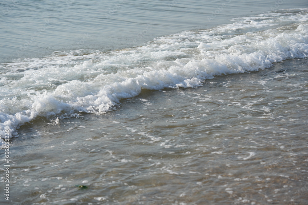 Fototapeta premium sea waves rolling on sandy beach – close-up shoreline sea waves gently rolling onto the sandy beach. clear water, foam, and soft motion create a calming natural seascape. ideal for vacation 