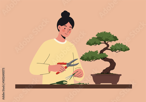 Woman tending to a bonsai tree, carefully pruning its branches with red handled shears, on a brown surface against a beige background.