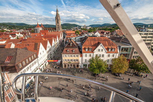 Aufsicht Reutlingen mit Marienkirche, Einkaufsstraße mit Marktplatz und Bäumen mit Herbstlaub, und Albpanorama mit blauem Himmel und Wolken