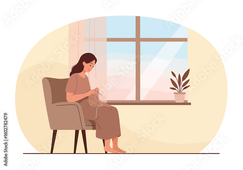 Woman knitting in a cozy armchair by a sunny window, enjoying a relaxing pastime.
