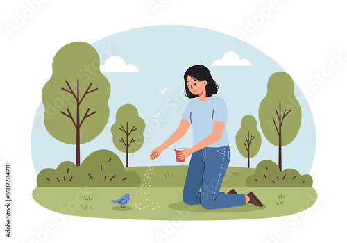 A young woman kneels on the grass in a park, offering food from a cup to a small blue bird.