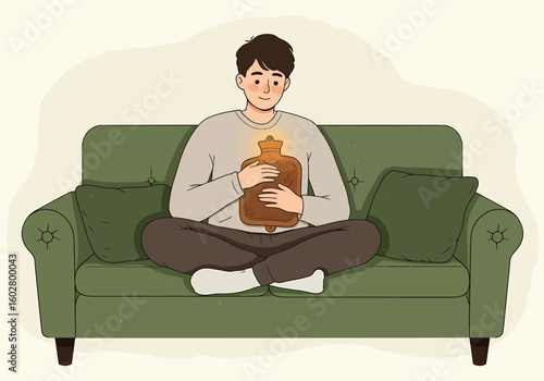 Man on a couch holding a hot water bottle for warmth.