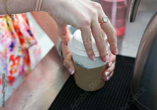 Woman opening coffee cup lid