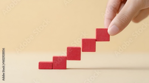 A hand is holding a stack of red blocks