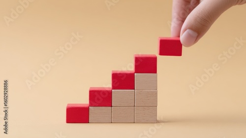 A hand is holding a red block and breaking it into smaller pieces