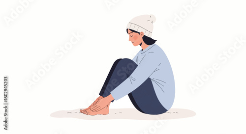 Young woman sitting comfortably on floor in cozy beanie, embracing leisure and self-care. Ideal for lazy day concepts and relaxation.