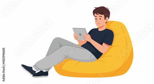 Relaxed young man lounging on a comfy yellow bean bag chair using a digital tablet, illustrating leisure, downtime & comfort.