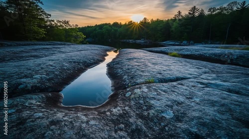 Sunset over calm lake and rocky shore