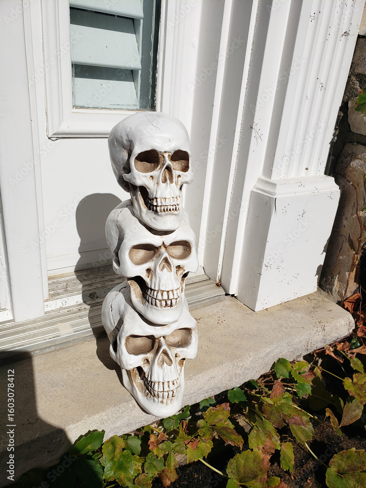 Fototapeta premium Traditional Halloween doorstep decorations for Americans. Skeletons and skulls at the door.