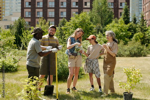 Принти на полотні Group of multiethnic adults and teenager gardening outdoors, planting young tree