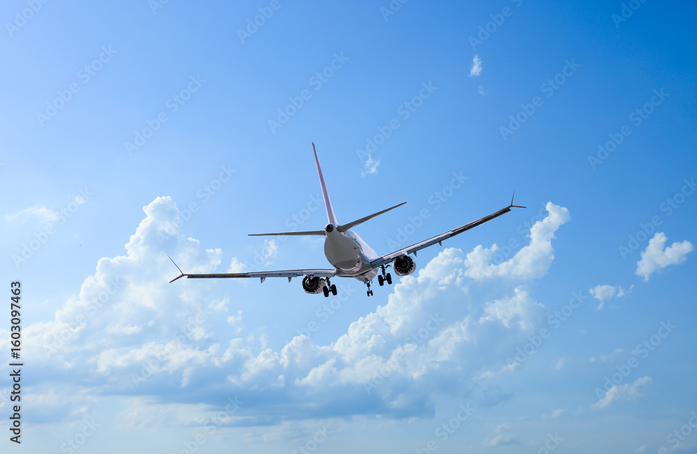 Obraz premium Airplane flying in beautiful blue sky with clouds