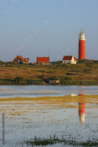 Portraitformat, Texel in the Netherlands, Lighthouse, lake, reflection of the lighthouse in the lake, nature reserve