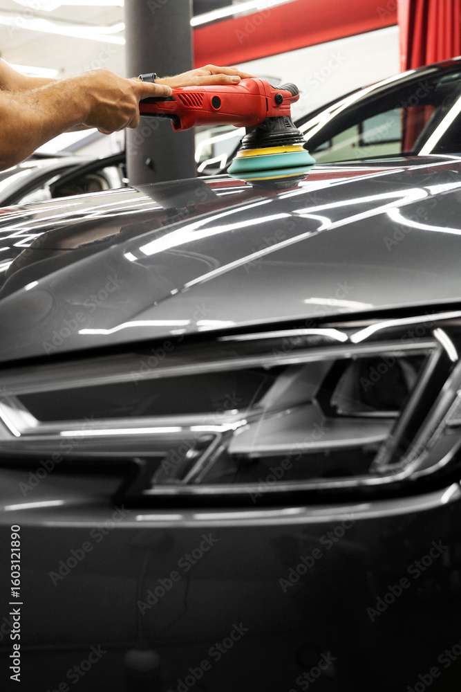 Fototapeta premium Car paint correction and polishing. Polishing machine expertly removes paint swirls and oxidation for a flawless surface. Polishing revives vehicle paint with deep gloss and smoothness.