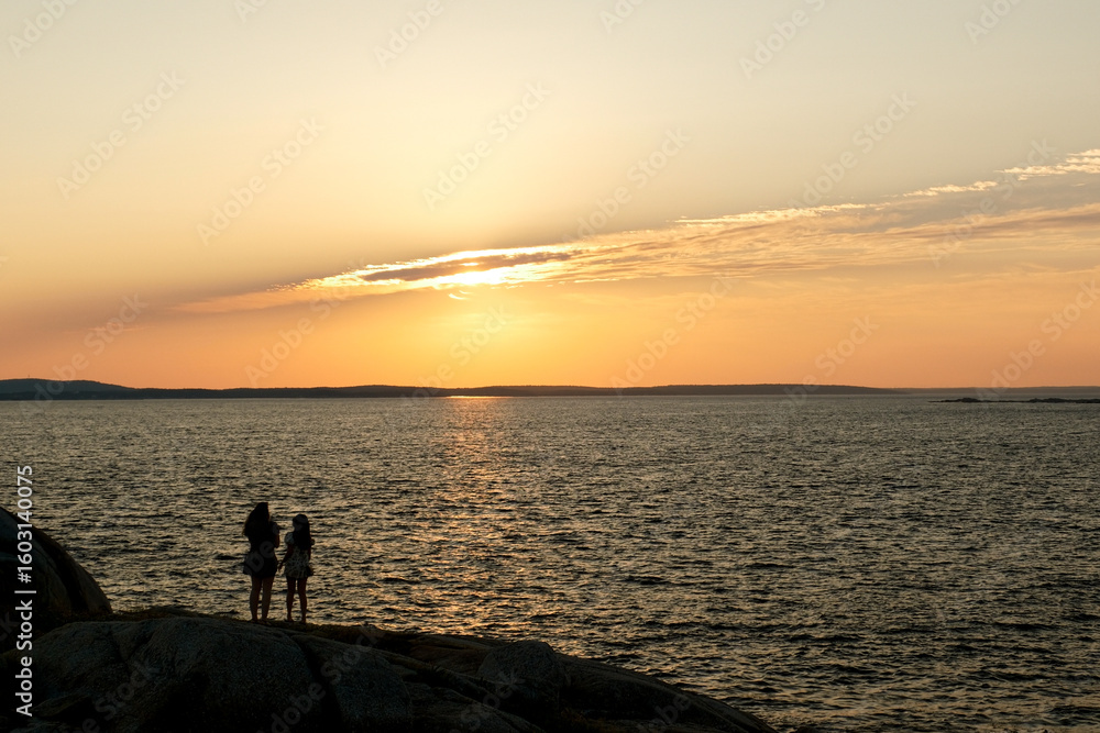 Fototapeta premium Enjoying the final moments of a perfect day on the coast at the Peggy's Cove Lighthouse
