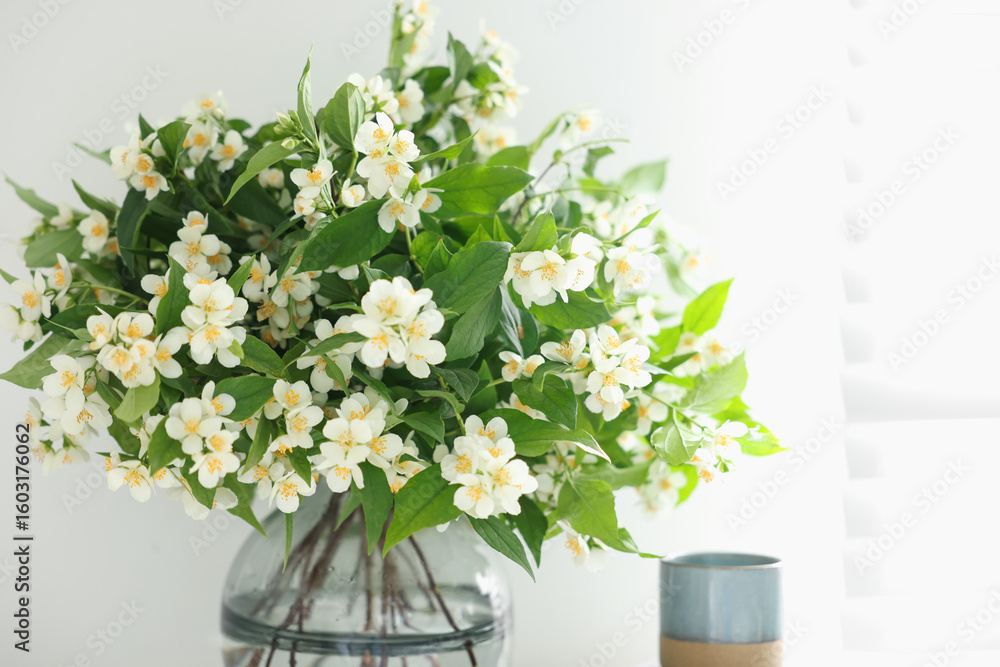 Fototapeta premium Beautiful jasmine flowers in vase and decor indoors, closeup