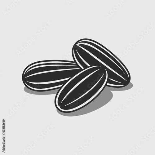 Three black and white sunflower seeds on a light gray background