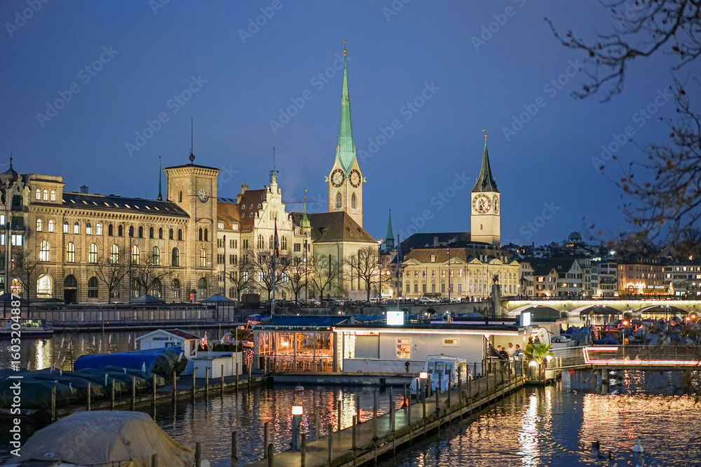 Fototapeta premium Evening view of the city of Zurich in Switzerland Several buildings and the tops of two churches are visible.