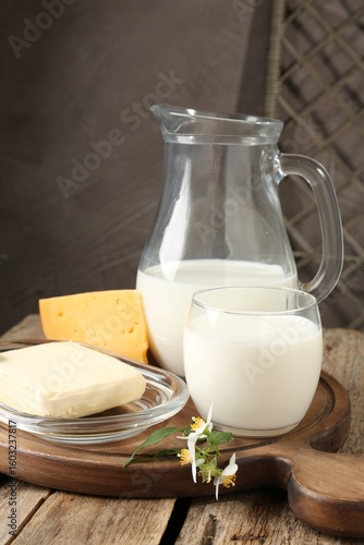 Bild auf Leinwand Different fresh dairy products and flowers on wooden table, closeup