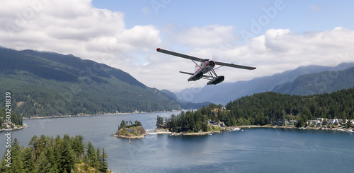 Konstfotografi Seaplane Flying Over Scenic Forested Lake with Mountain Background