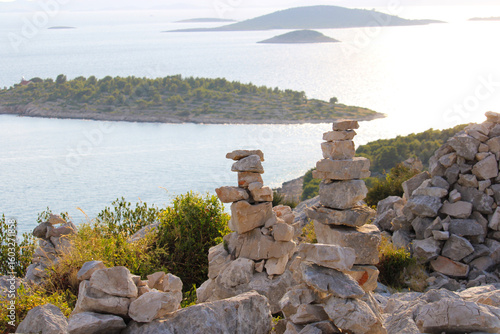 pile of rocks in front of kornati islands skyline in blue ocean, viewpoint veli vrh, Murter, Croatia
