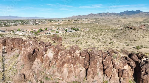 Aerial Tracking Shot Over Desert Cliffs and Small Town Edge Arizona