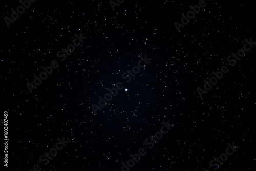 Bright star centered in clear night sky with stars scattered in darkness