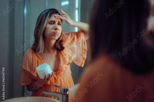 Papier peint Woman Worried About the Effects of Aging Using a Face Cream