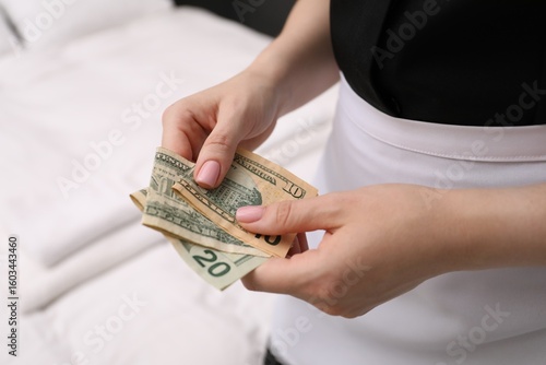 Tableau sur toile Chambermaid with tips indoors, closeup. Gratuity for work