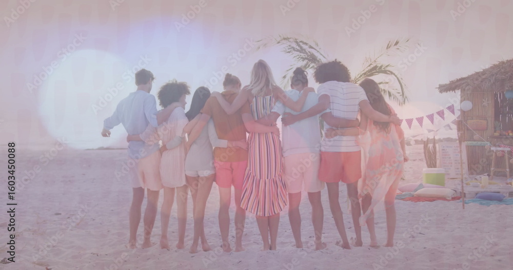 Obraz premium Standing friends linking arms facing ocean on sandy beach at sunset, with palm tree and bunting