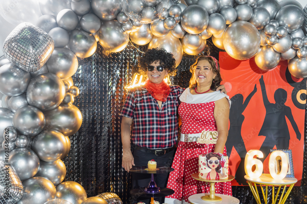 Fototapeta premium Senior couple celebrating 60th birthday with disco themed party