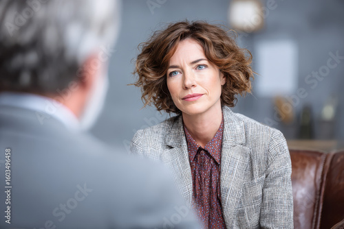 A woman listening attentively during a serious conversation. The scene captures the intensity of the interaction. The lady appears to be thoughtful and focused on the discussion.