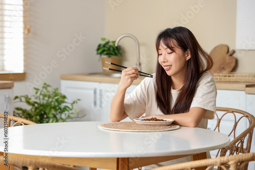 Young Asian woman eating fr...