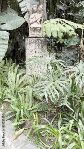 Ancient Stone Statue Amidst Lush Mexican Garden Foliage