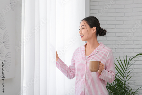 Young Asian woman in pajama...