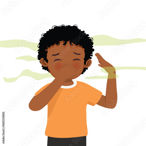Little African boy smelling something stinky pinching and covering his nose with his hand