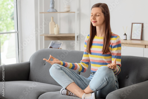 Young woman meditating on s...