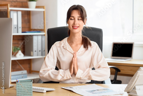 Young businesswoman meditat...