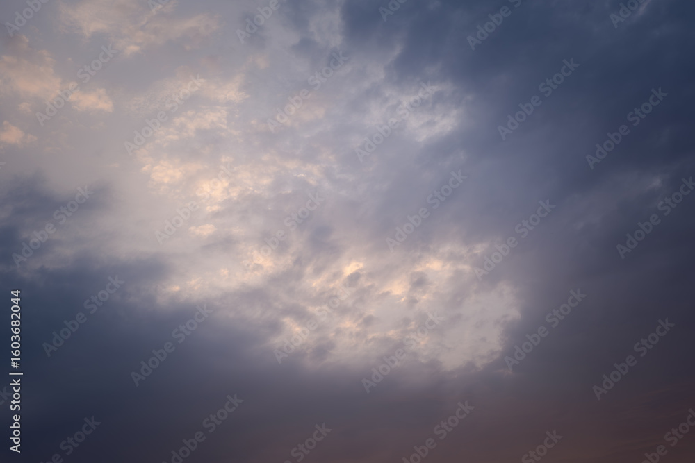 Naklejka premium A cloudy sky with a sun peeking through the clouds