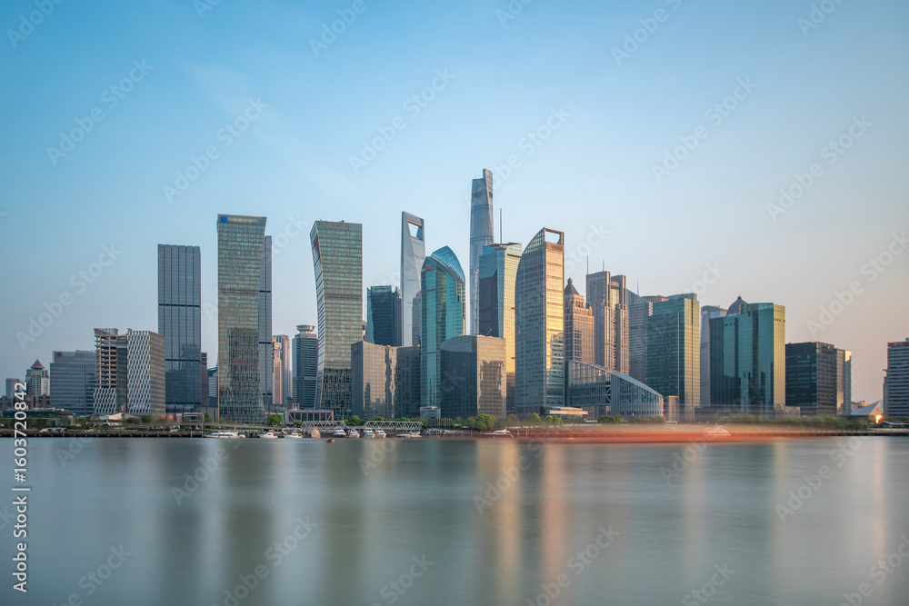 Fototapeta premium Modern city skyline with tall buildings reflecting in the water