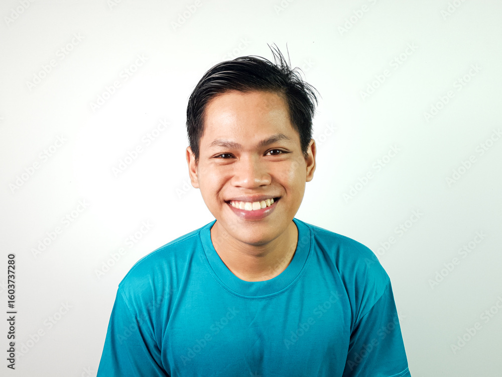 Portrait of Smiling Young Asian Man Wearing a Blue Shirt on a White Background Portrait of Smiling Young Asian Man Wearing a Blue Shirt on a White Background