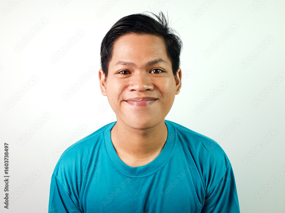 Portrait of Smiling Young Asian Man Wearing a Blue Shirt on a White Background Portrait of Smiling Young Asian Man Wearing a Blue Shirt on a White Background