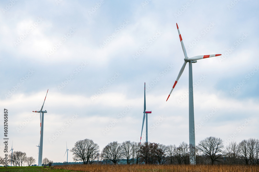 Windmill in rural autumn area. Offshore wind park. Wind turbines farm. Alternative renewable energy generation. Green energy concept. Wind mill for renewable electric energy production Windmill in rural autumn area. Offshore wind park. Wind turbines farm. Alternative renewable energy generation. Green energy concept. Wind mill for renewable electric energy production