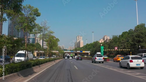 Exploring urban driving along a busy highway under clear blue skies in a vibrant city setting
