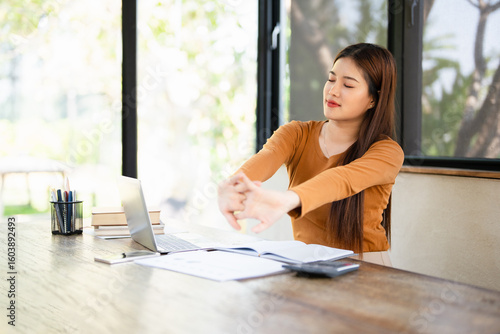 Free Download Office asian business woman stretching body for relaxing while working with laptop computer at her desk, office lifestyle, business situation. - GFXLoad