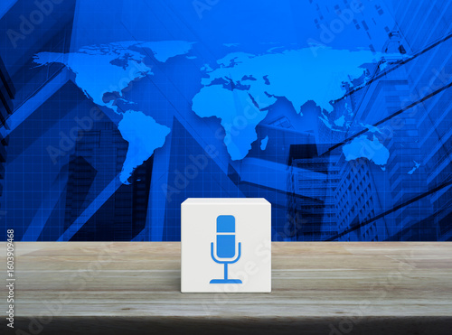 Fototapeta Naklejka Na Ścianę i Meble -  Microphone icon on white block cube on wooden table over world map, modern office city tower and skyscraper, Technology communication concept, Elements of this image furnished by NASA