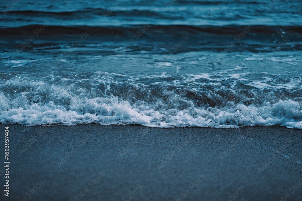 Fototapeta premium Ocean waves crashing on a beach at dusk